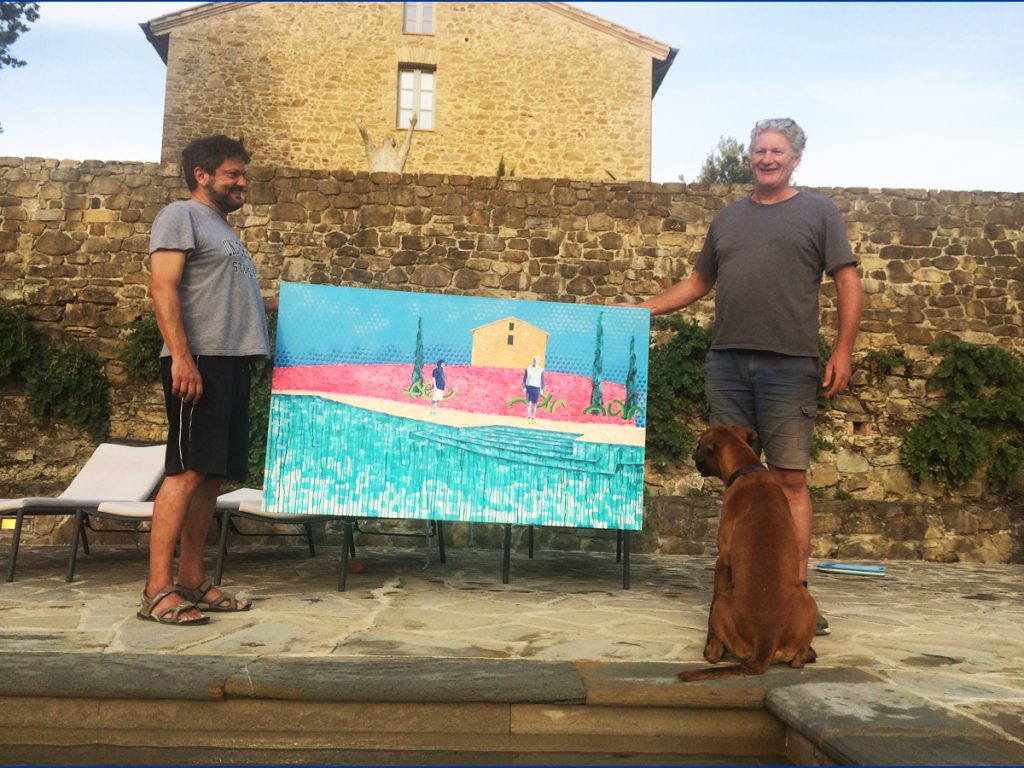 Andrew and Hugue holding the painting by the pool